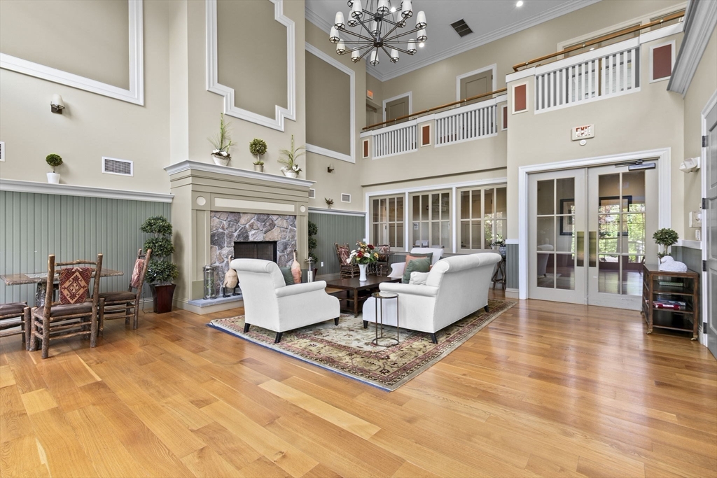 59 Walpole Street, Unit 116 Canton, MA 02021 - Photo 17 of 26 a living room with furniture a fireplace and a chandelier