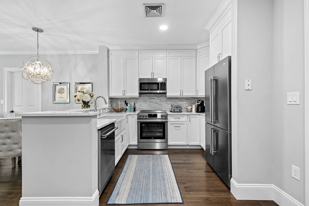 59 Walpole Street, Unit 116 Canton, MA 02021 - Photo 3 of 26 a kitchen with a refrigerator and a stove top oven