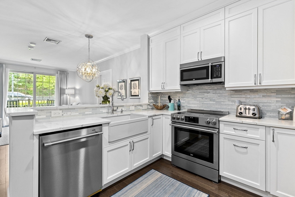 59 Walpole Street, Unit 116 Canton, MA 02021 - Photo 4 of 26 a kitchen with granite countertop white cabinets white stainless steel appliances and a sink