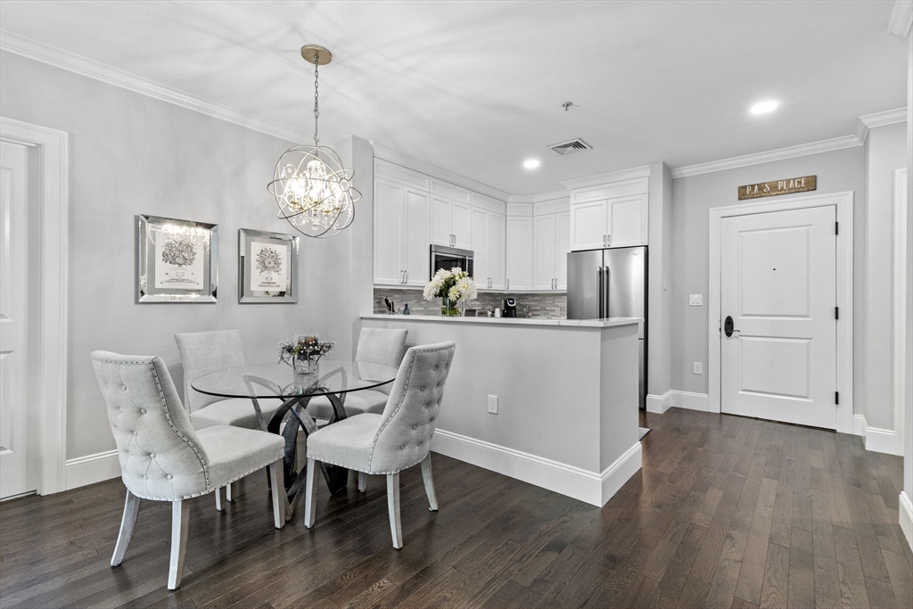 59 Walpole Street, Unit 116 Canton, MA 02021 - Photo 5 of 26 a dining room with furniture a chandelier and wooden floor