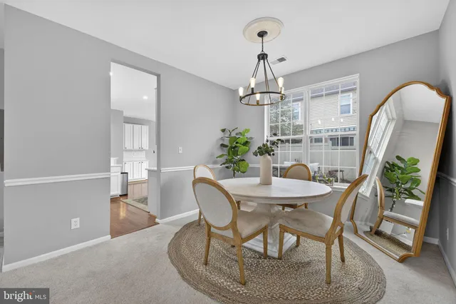 a dining room with furniture a chandelier and wooden floor