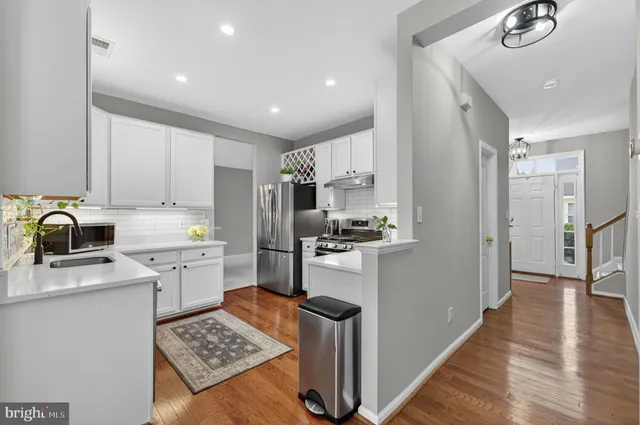 a kitchen with cabinets stainless steel appliances and wooden floor