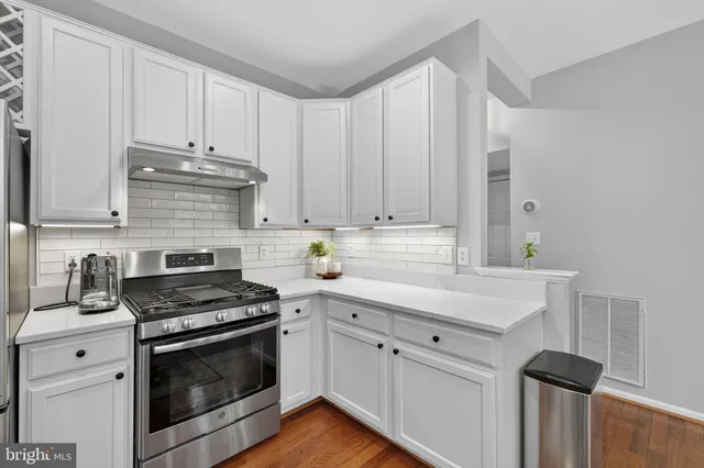 a kitchen with a sink cabinets and wooden floor