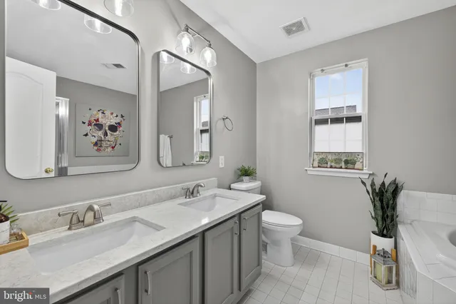 a bath room with a toilet a bath tub and a sink