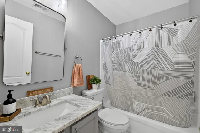 a front view of a house with a large window and potted plants