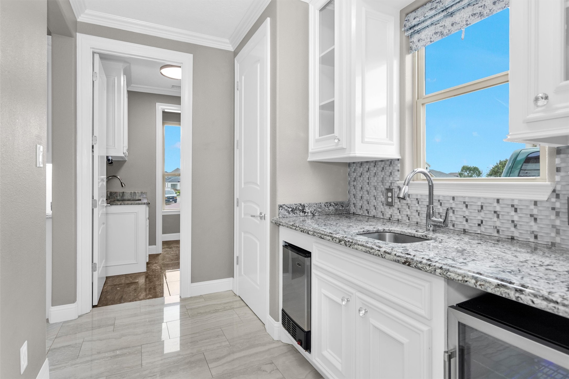10887 Decatur Street Willis, TX 77318 - Photo 20 of 50 Well-equipped butler’s pantry adds serious functionality with its own sink, ice machine, and wine/beverage refrigerator—perfect for entertaining, extra prep space or keeping everything organized and out of the main kitchen.