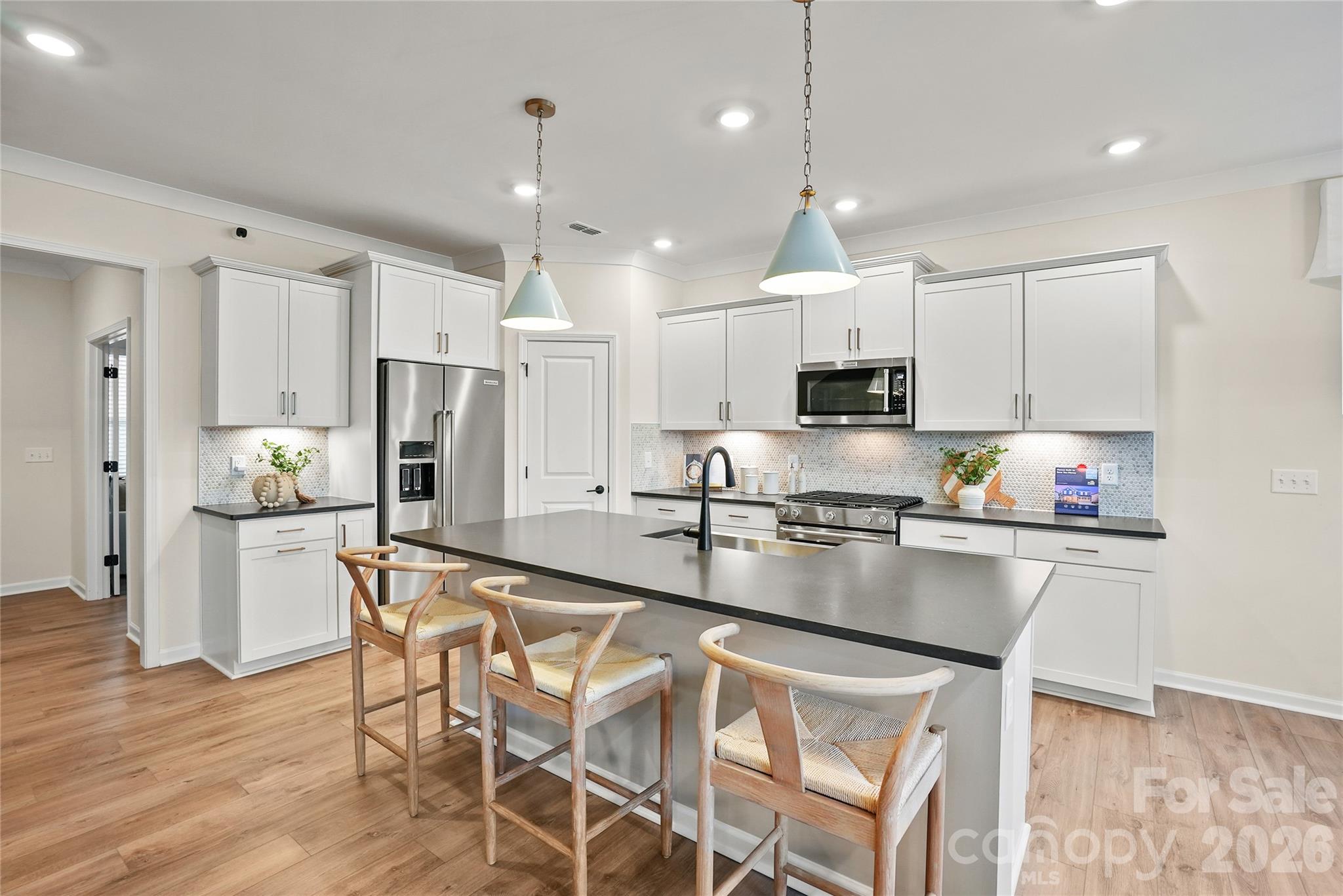 2149 Riverbend Avenue Monroe, NC 28110 - Photo 5 of 22 a kitchen with stainless steel appliances granite countertop a stove top oven a refrigerator a sink and chairs