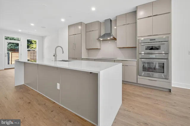 a kitchen with stainless steel appliances a sink stove and refrigerator