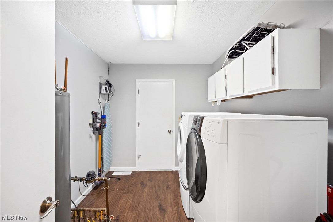 10798 Gate Post Road Strongsville, OH 44149 - Photo 20 of 32 Clothes washing area featuring cabinets, dark hardwood floors, water heater, and washer and clothes dryer