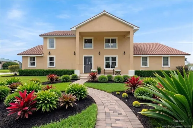 a front view of a house with a yard and potted plants