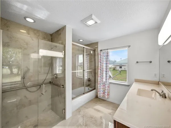 a bathroom with a tub shower and sink