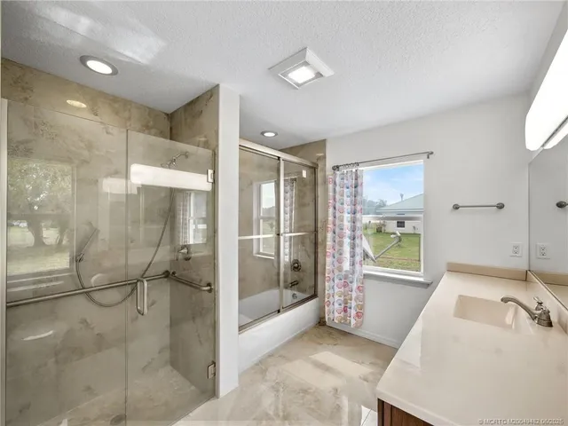 a bathroom with a tub shower and sink