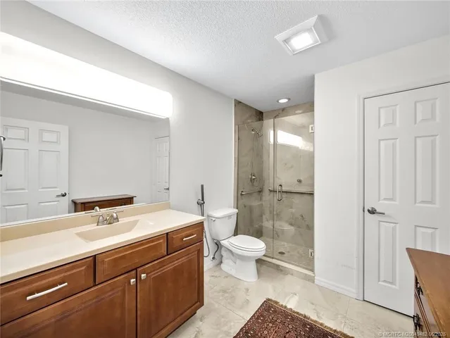 a bathroom with a sink a toilet and shower