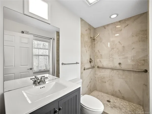 a bathroom with a sink mirror toilet and shower
