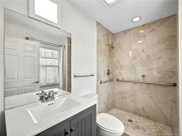 a bathroom with a sink mirror toilet and shower