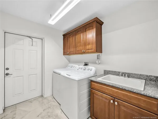 a utility room with a sink washer and dryer