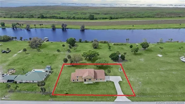 an aerial view of green landscape with trees houses and lake view