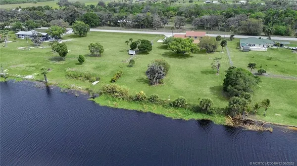 an aerial view of green landscape with trees and houses