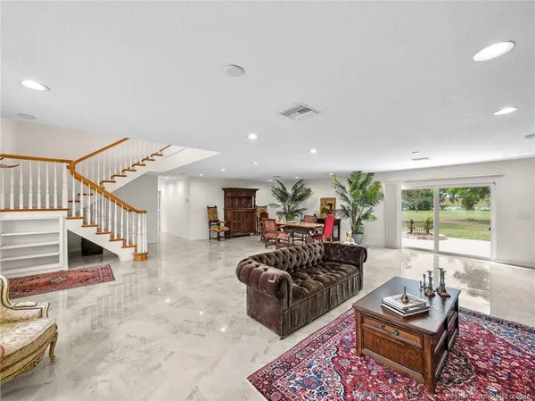 a living room with furniture stairs and a window
