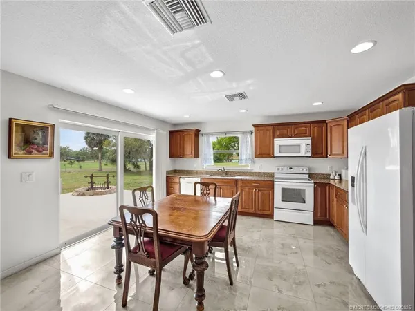 a kitchen with a table chairs refrigerator and cabinets