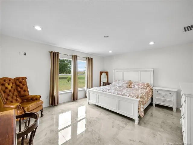 a bedroom with a bed and large windows