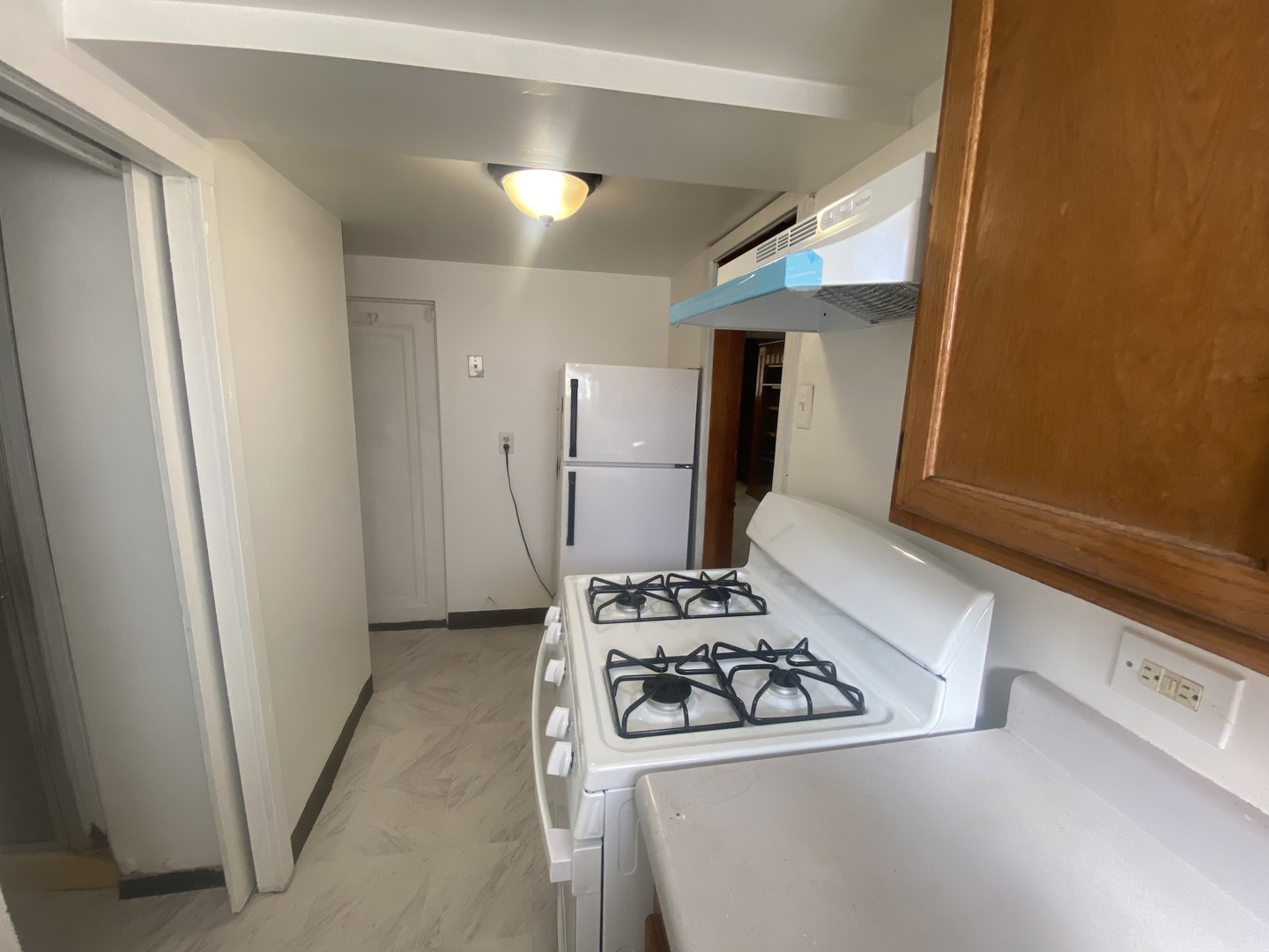 5514 North Mango Avenue, Unit G Chicago, IL 60630 - Photo 6 of 9 a kitchen with a stove and a refrigerator
