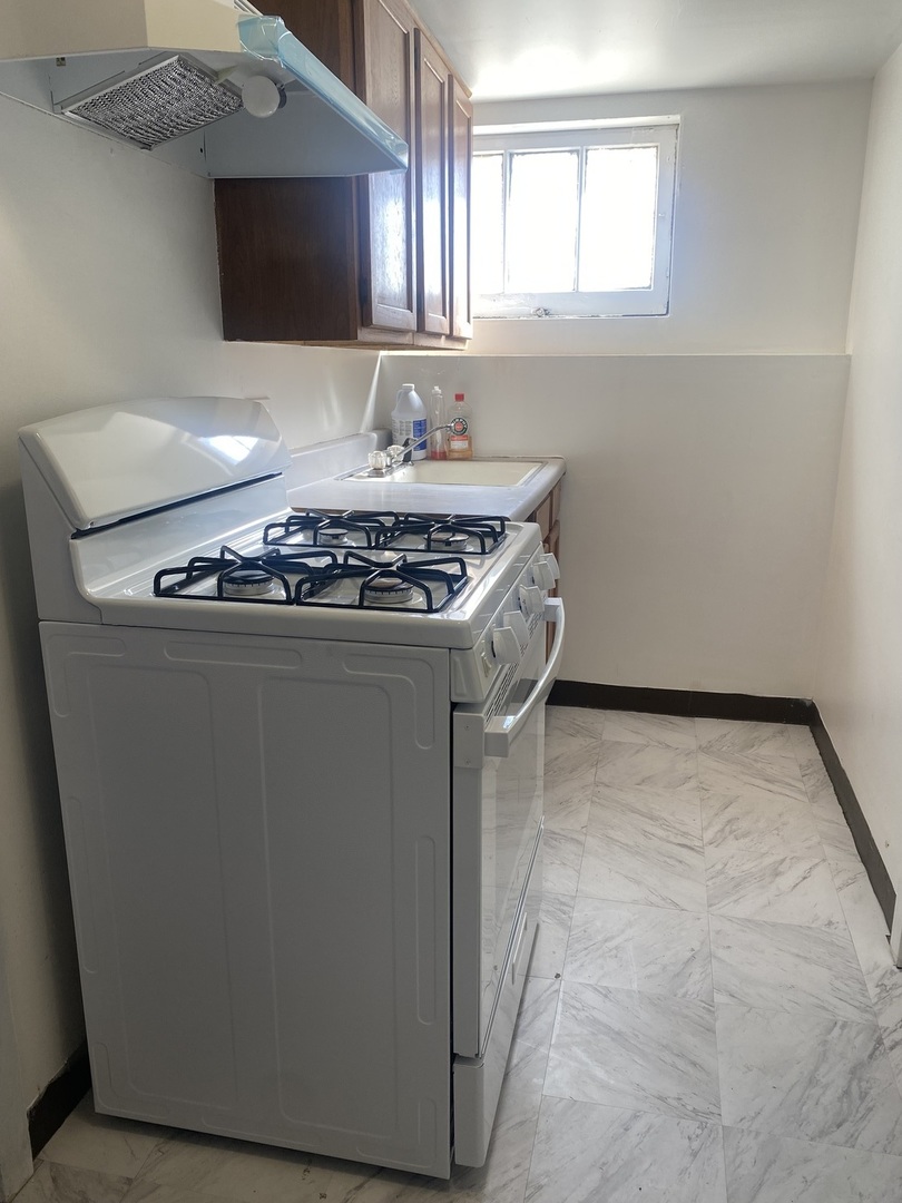 5514 North Mango Avenue, Unit G Chicago, IL 60630 - Photo 8 of 9 a kitchen with a stove and a microwave