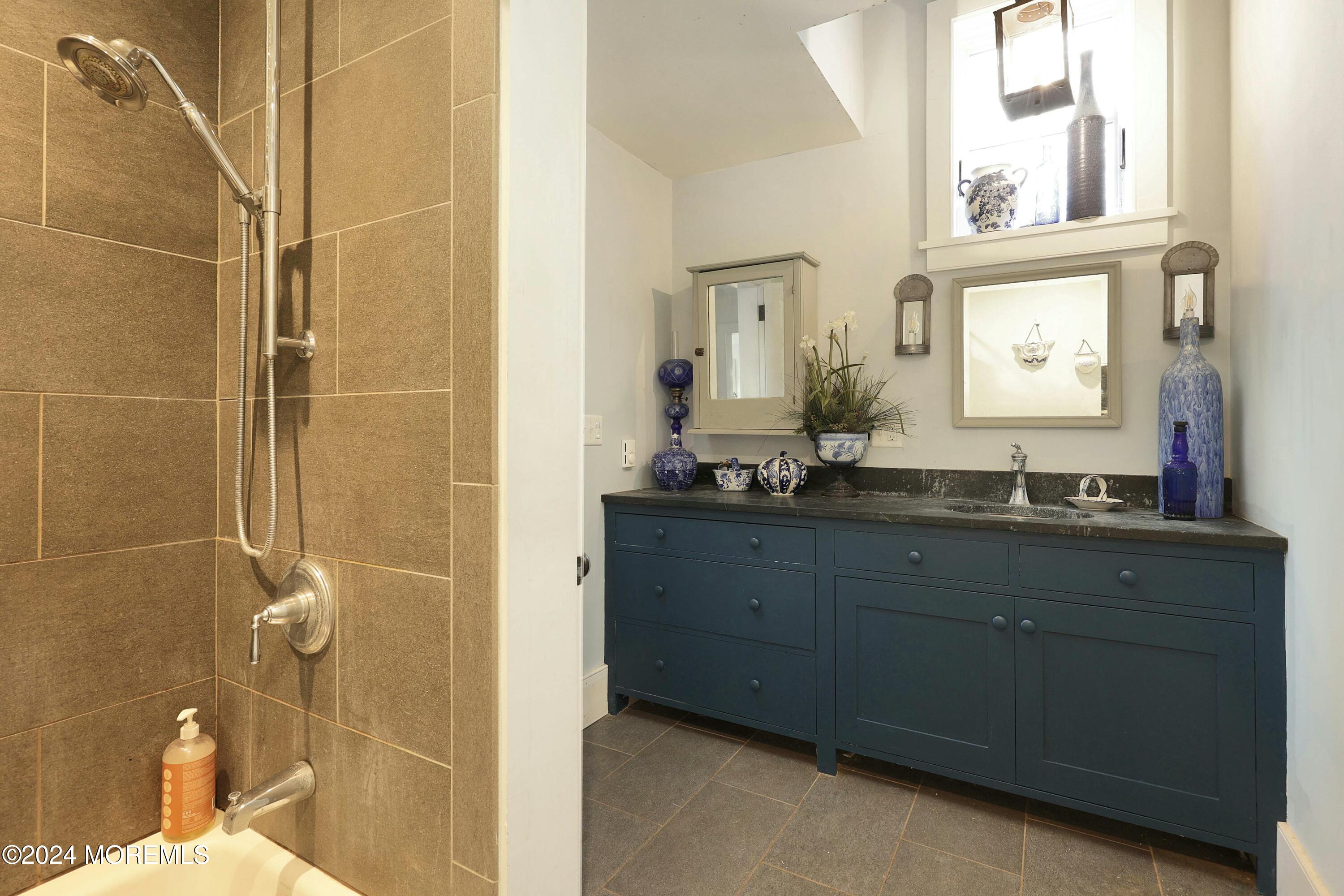125 Sandy Ridge Road Stockton, NJ 08559 - Photo 29 of 46 a bathroom with a granite countertop sink a mirror and a shower