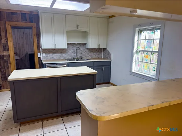 a kitchen with a sink a stove and cabinets