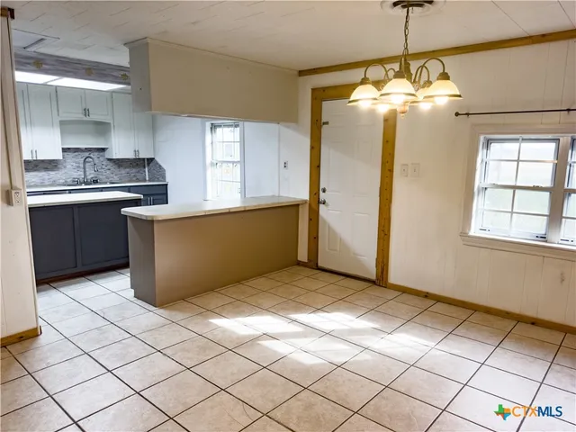 a view of a kitchen with kitchen island granite countertop cabinets and window