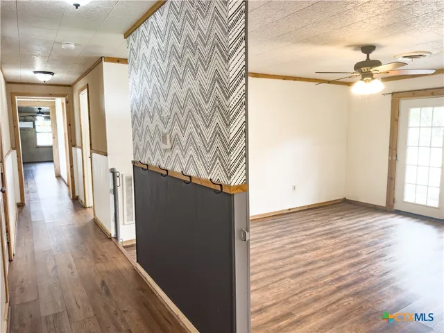 a view of empty room with wooden floor and window