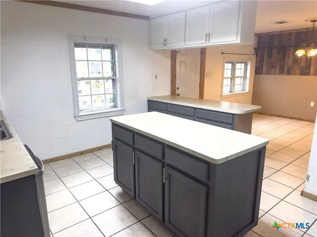 a kitchen with a sink cabinets and a window