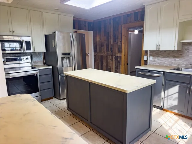 a kitchen with stainless steel appliances a refrigerator and a stove