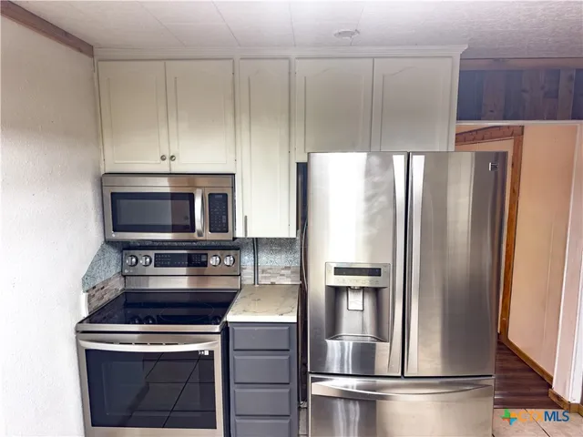 a kitchen with a refrigerator stove and microwave