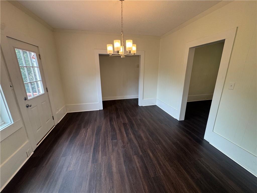 24 Lower Street Valley, AL 36854 - Photo 9 of 18 Unfurnished dining area with dark wood-type flooring, a chandelier, and crown molding