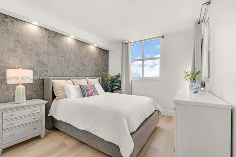a bedroom with a bed and a potted plant