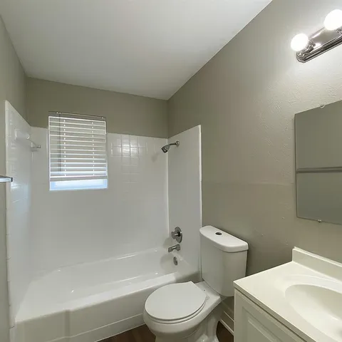 a white toilet sitting next to a bath tub