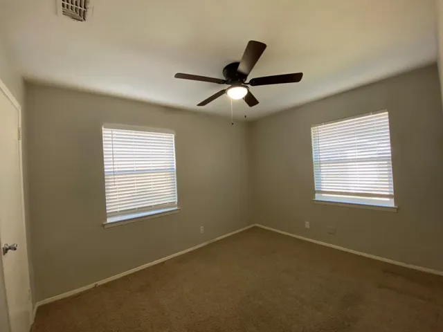 a view of a livingroom with a ceiling fan and window