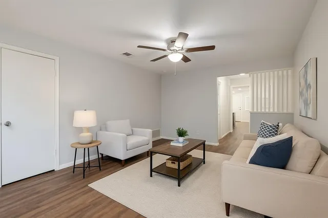 a living room with furniture and a wooden floor