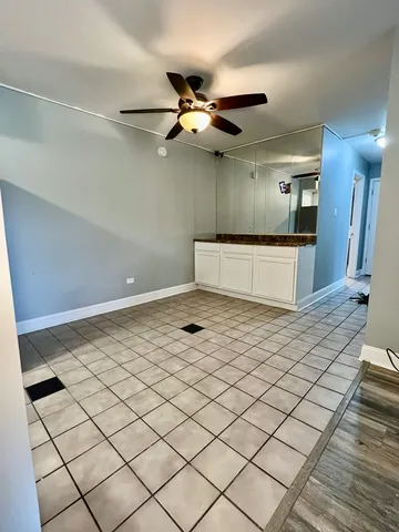 a living room with a ceiling fan and wooden floor