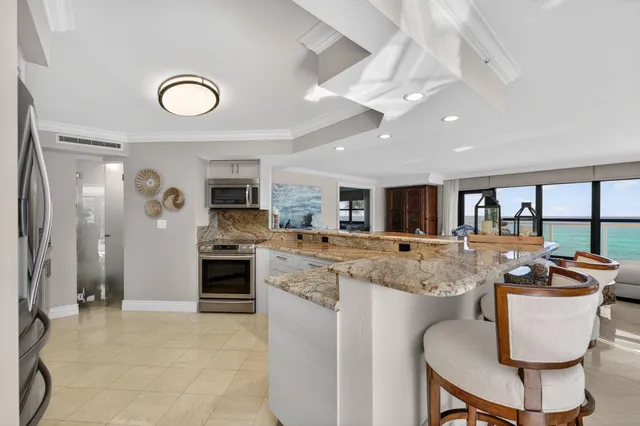 a dining room with furniture a chandelier and a floor to ceiling window
