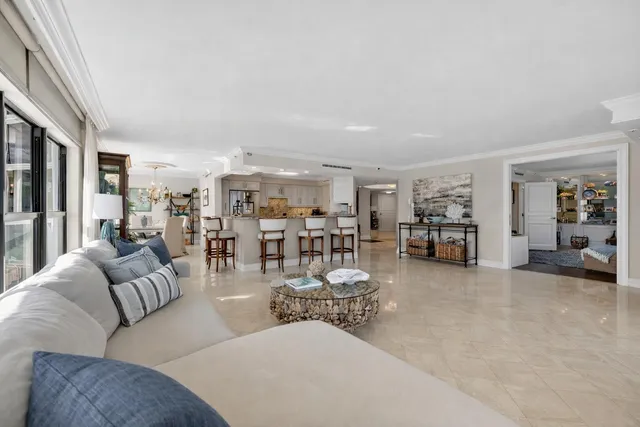 a living room with furniture a table gym equipment and a large window