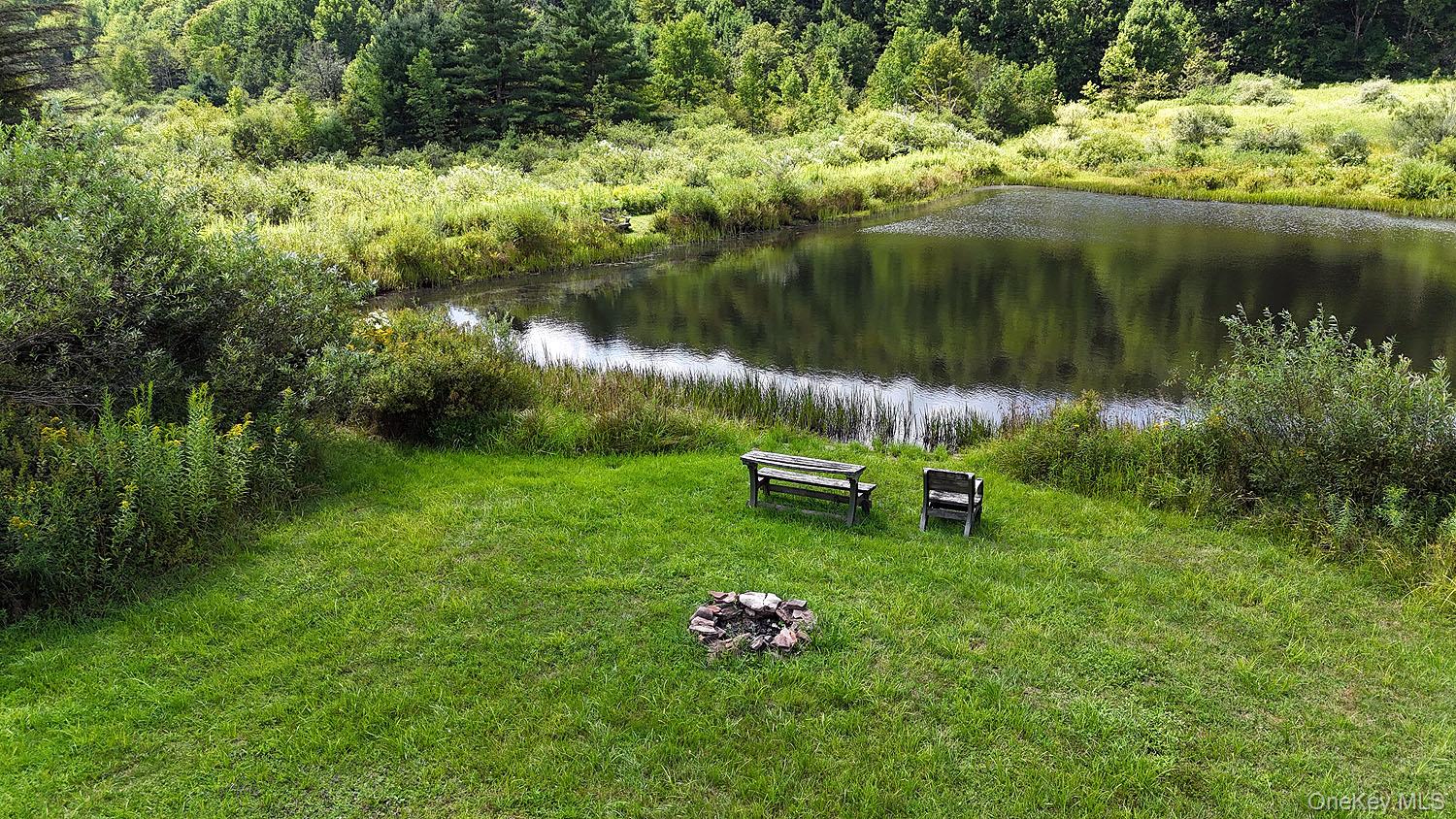 3392 Eminence Road Hancock, NY 12760 - Photo 6 of 43 a garden with wooden bench and lake view