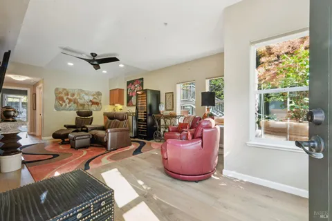 a living room with furniture a flat screen tv and a large window