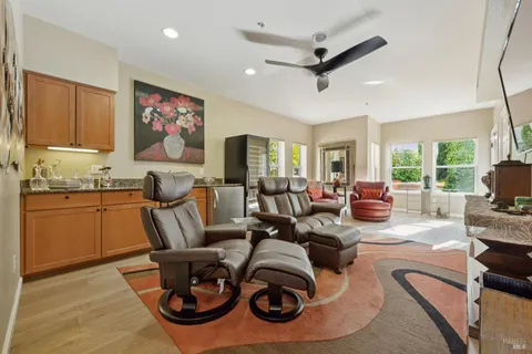 a living room with furniture kitchen view and a large window
