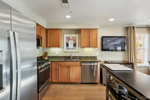 a kitchen with stainless steel appliances granite countertop a sink stove and refrigerator