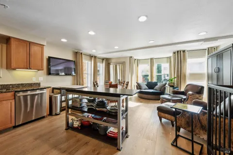 a living room with furniture a flat screen tv and floor to ceiling window
