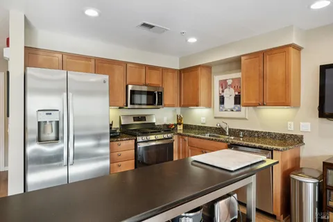 a kitchen with stainless steel appliances granite countertop a stove and cabinets