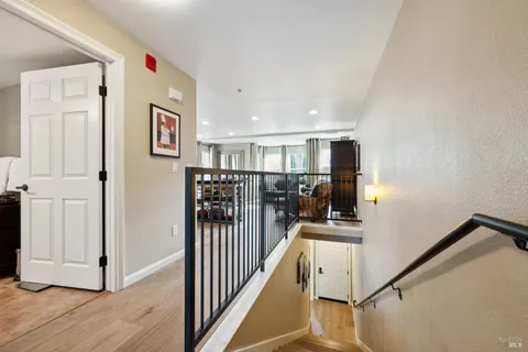 a view of a hallway with wooden floor and staircase
