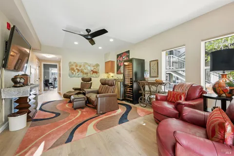 a living room with furniture a flat screen tv and kitchen view